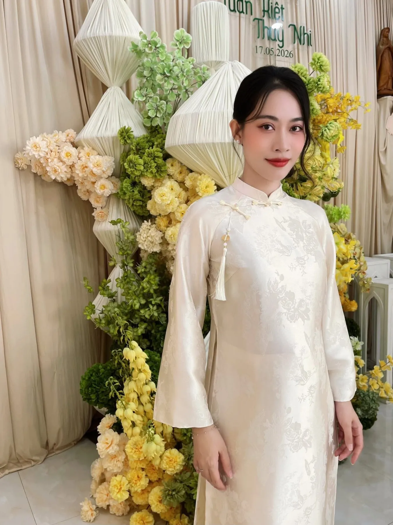 Bạch Quyên mặc áo dài trắng trong một lễ tân hôn